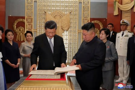 North Korean leader Kim Jong Un and Chinese President Xi Jinping look at a book during Xi's visit in Pyongyang