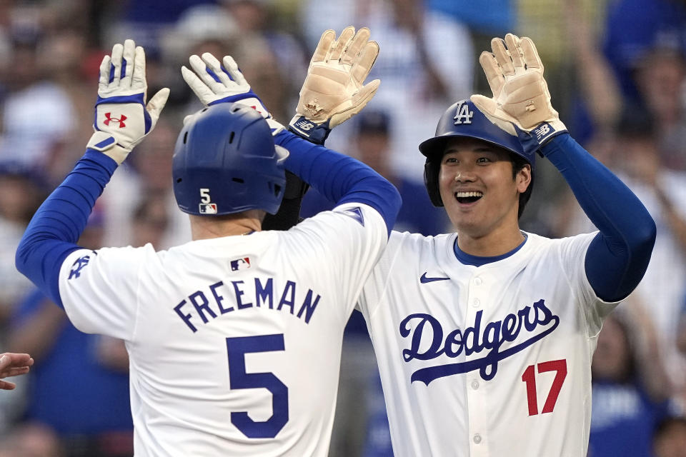 Los Angeles Dodgers' Freddie Freeman, left, is congratulated by Shohei Ohtani after hitting a three-run home run during the first inning of a baseball game against the Arizona Diamondbacks Wednesday, July 3, 2024, in Los Angeles. (AP Photo/Mark J. Terrill)