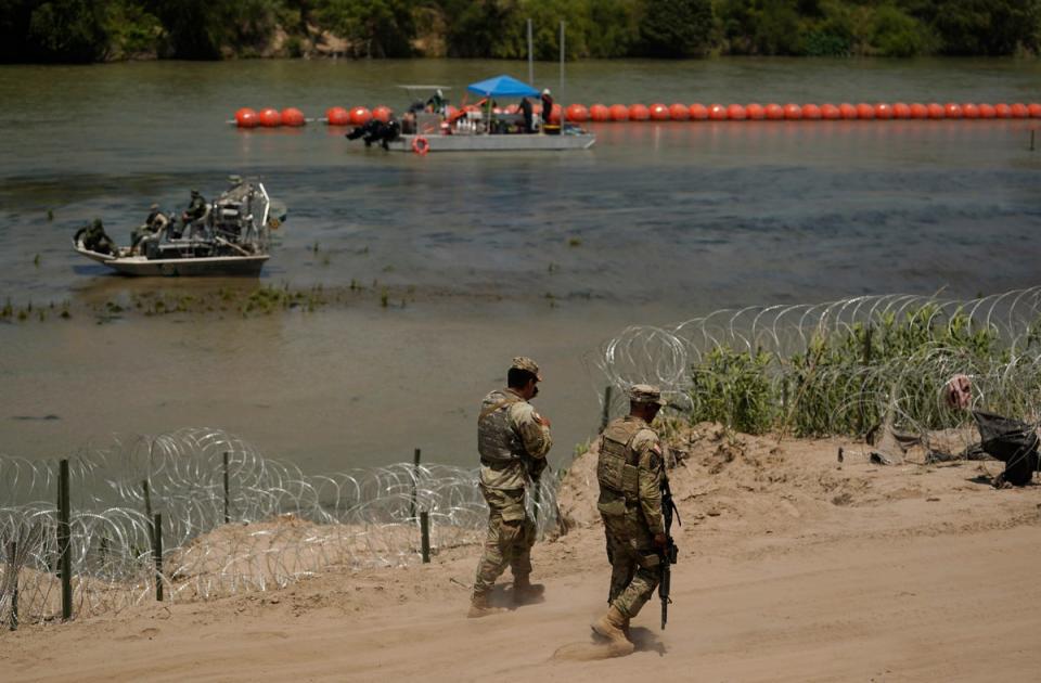 Guardsmen patrol as workers continue to deploy large buoys to be used as a border barrier along the banks of the Rio Grande in Eagle Pass, Texas, Wednesday, July 12, 2023 (Copyright 2023 The Associated Press. All rights reserved)