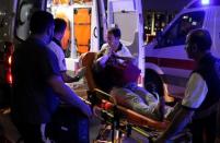 An injured woman covers her face as she is carried by paramedics into ambulance at Istanbul Ataturk airport, Turkey, following a blast June 28, 2016. REUTERS/Goran Tomasevic