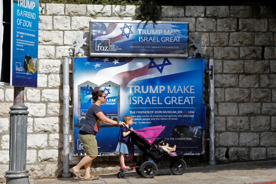 <p>People walk past a banner in support of U.S. President Donald Trump on the day of his visit in Jerusalem on May 22, 2017. (Photo: Menahem Kahana/AFP/Getty Images) </p>