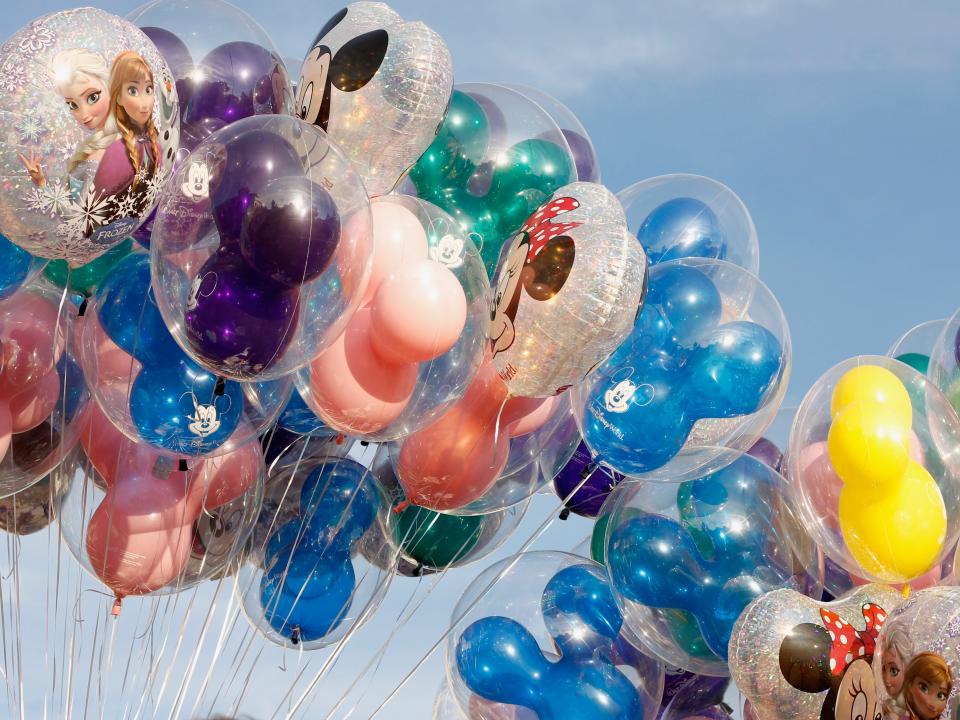 photo of a bundle of disney balloons against a blue sky
