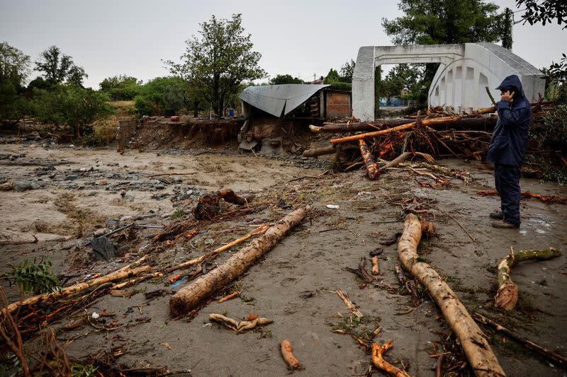 A person inspects the damage after another storm in Lechonia