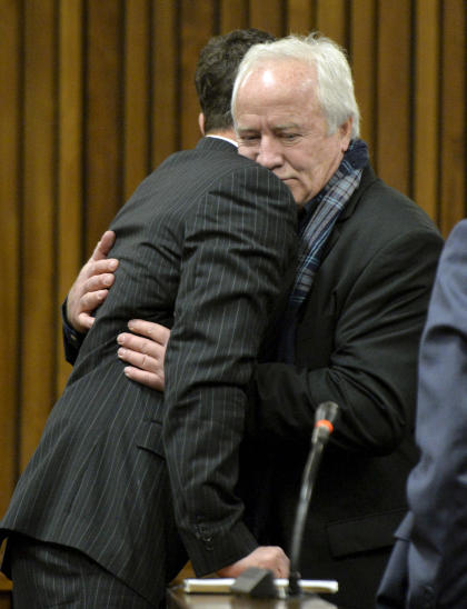 Oscar Pistorius, left, gets a hug from his estranged father, Henk Pistorius, right, in court Friday. (AP)