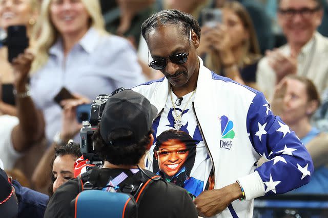 <p>Arturo Holmes/Getty</p> Snoop Dogg wears a shirt with Simone Biles’ face on it on July 28, 2024