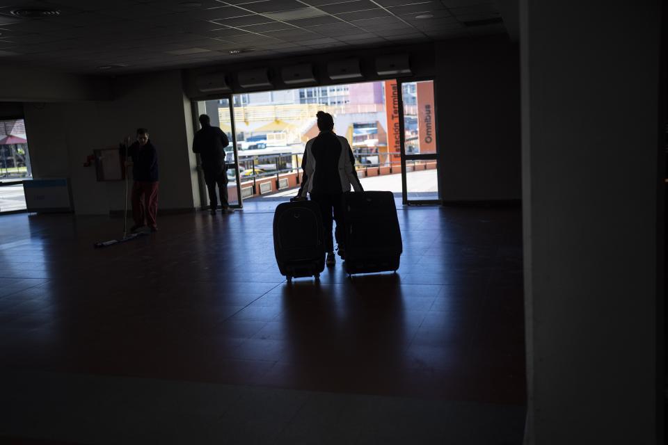 A traveler exits the Retiro long-distance bus terminal that is mostly empty due to a general strike against the reforms of President Javier Milei, in Buenos Aires, Argentina, Thursday, May 9, 2024. (AP Photo/Rodrigo Abd)