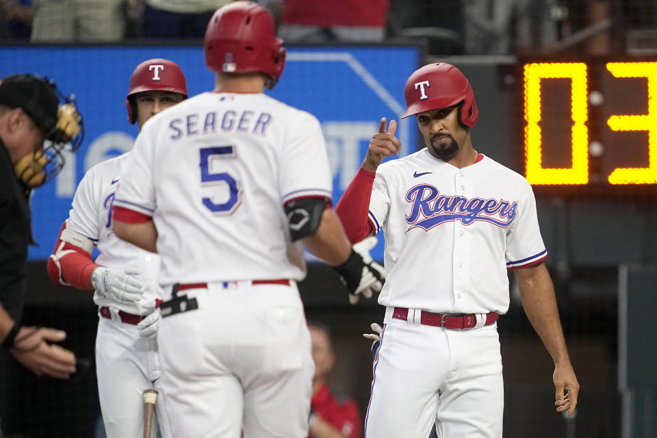 Texas Rangers' Corey Seager (5) and Marcus Semien, right, celebrate at the plate after Seager hit a two-run home run that scored Semien in the first inning of a baseball game against the Houston Astros, Monday, Sept. 4, 2023, in Arlington, Texas. (AP Photo/Tony Gutierrez)