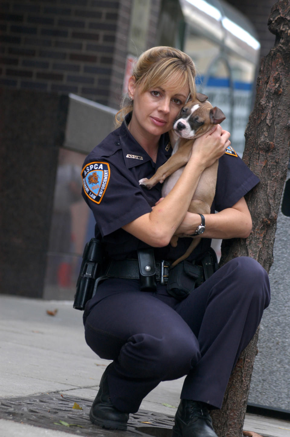 FILE -This 2004 photo provided by Animal Planet shows investigator Annemarie Lucas of the Humane Law Enforcement division of the American Society for the Prevention of Cruelty to Animals with a rescued dog in New York. ASPCA agents wore uniforms, flashed badges, carried guns, traveled in blue-and-white squad cars, and for years starred in “Animal Precinct,” as did Lucas, but as of this month, the ASPCA laid off almost all of its 18 law enforcement agents and is now leaving those responsibilities solely to the New York City Police Department. (AP Photo/Animal Planet, Laura Pedrick)