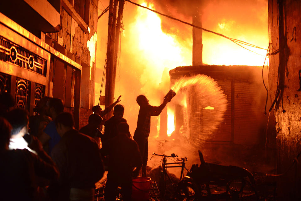 In this Wednesday, Feb. 20, 2019, file photo, firefighters and local people help douse a fire in Dhaka, Bangladesh. After more than 1,100 people died when a garment factory complex collapsed in Dhaka, Bangladesh authorities imposed more stringent safety rules. But corruption and lax enforcement have resulted in many more deaths linked to safety lapses since the 2013 Rana Plaza disaster, including a fire Thursday in an illegally-constructed high-rise office building that killed at least 25 people and left dozens more injured. (AP Photo/Mahmud Hossain Opu, File)