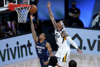 Dallas Mavericks Trey Burke (32) shoots under Utah Jazz's Rayjon Tucker (6) during the second half of an NBA basketball game Monday, Aug. 10, 2020, in Lake Buena Vista, Fla. (AP Photo/Ashley Landis, Pool)