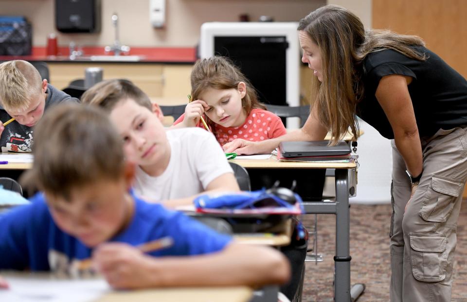 Northwest School District W.S. Stinson Elementary School fifth grade teacher Pam Kurz helps her student Anna DeLunger in class in this file photo from 2023.