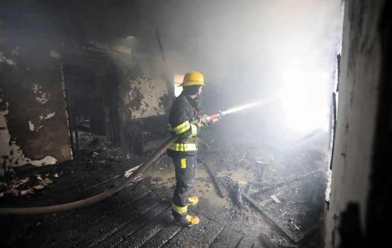 A firefighters extinguishes a fire in a house caused by shelling in the fighting over the breakaway region of Nagorno-Karabakh in the town of Barda