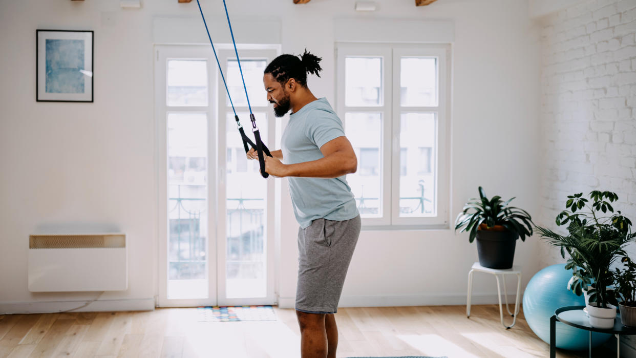  Man exercising with resistance bands at home 