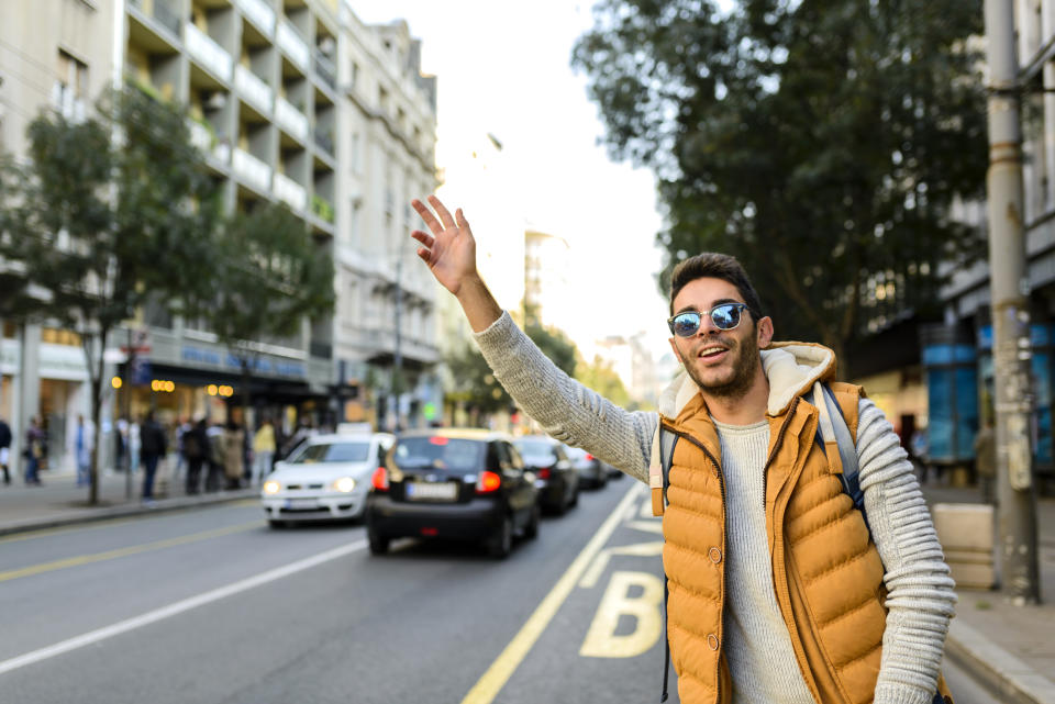 A young man hailing a cab.