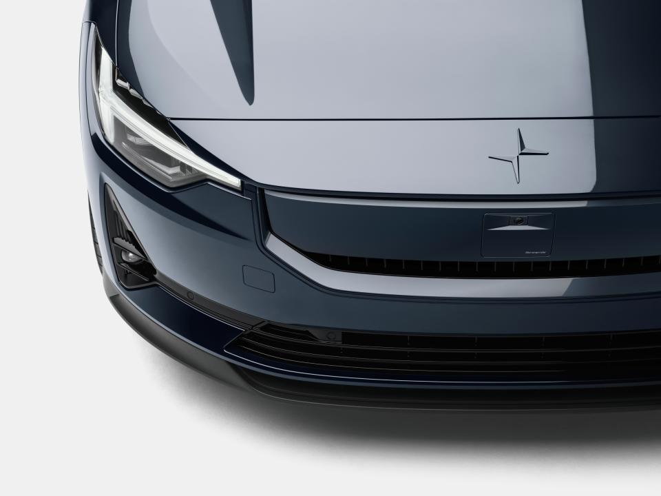 The front end of the polestar 2 in dark grey, showing the SmartZone sensor suite which really just looks like a little dimple in the front grille directly beneath the PS hood ornament