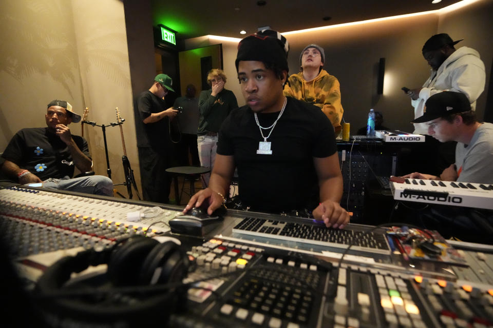 Record producer and songwriter Turbo, center, mixes a recording session for an extended play at Interscope Records Studios In Santa Monica, Calif., Wednesday, June 21, 2023, as New York Giants tight end Darren Waller, looks on at left. The NFL, Interscope Geffen A&M Records and Electronic Arts Sports have partnered to empower NFL players to pursue their passion of music and create the extended play project "Crowd Control." Songs from the EP were inserted into the video game "Madden NFL 24," released last month. (AP Photo/Damian Dovarganes)