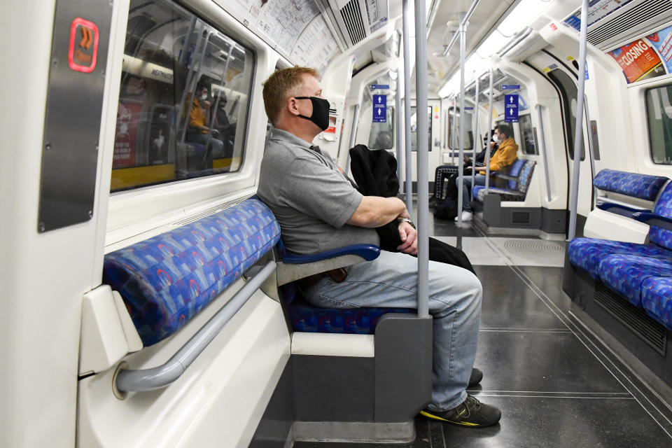 A man wears a face mask to protect against infection from coronavirus as he sits on an Underground train, in London, Tuesday, Sept. 8, 2020. (AP Photo/Alberto Pezzali)