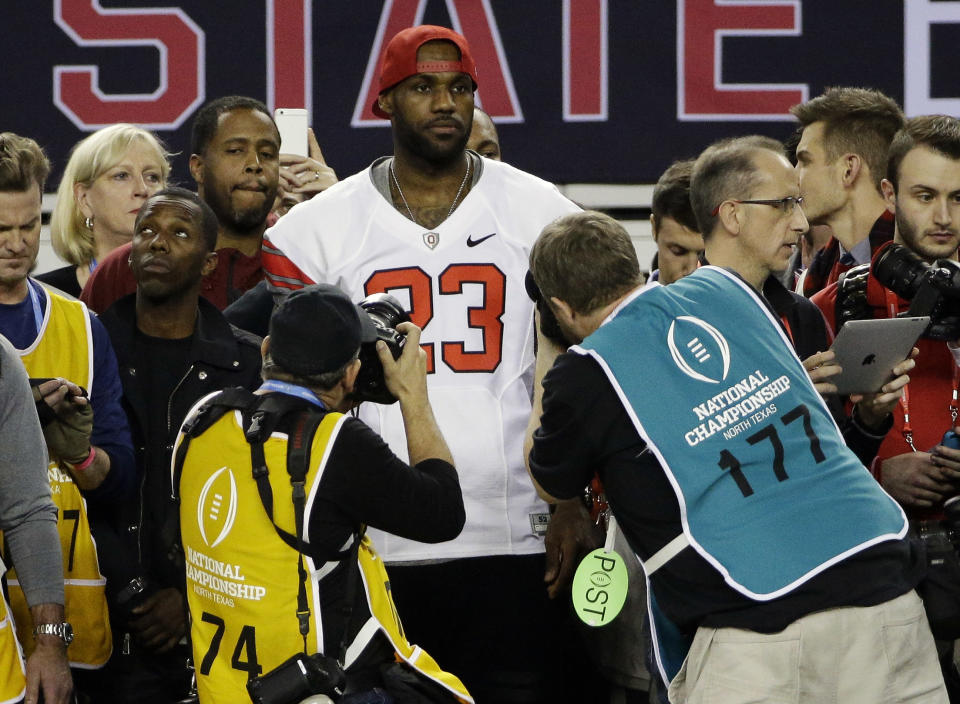 NBA basketball player LeBron James stands on the sideline during the second half of the NCAA college football playoff championship between Ohio State and Oregon game Monday, Jan. 12, 2015, in Arlington, Texas. Ohio State won 42-20. (AP Photo/David J. Phillip)