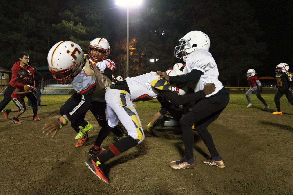 This photo provided by the University of Maryland shows a Maryland Heat youth tackle football team practicing in Fort Washington, Md., Nov. 9, 2023. Some parents are opting to enroll their children in leagues that play flag football, which limits contact on the field. But youth tackle leagues remain popular in many parts of the country. (Univ. of Maryland/Freddy Wolfe via AP)