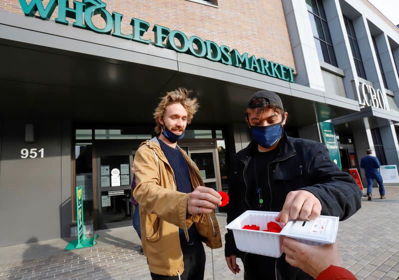 Shoppers take poppies as they pass by a Whole Foods store in Ottawa