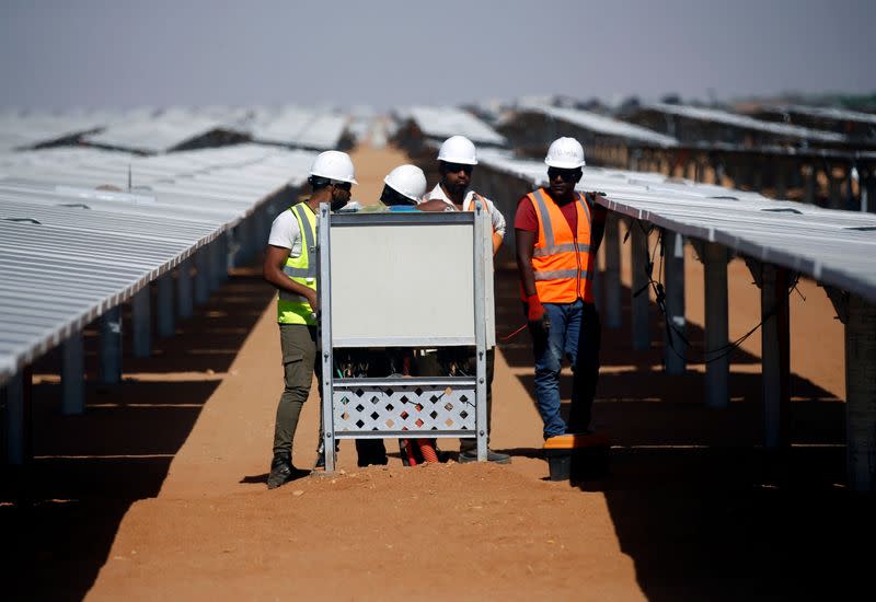 Workers set up the photovoltaic solar panels at the Benban plant in Aswan