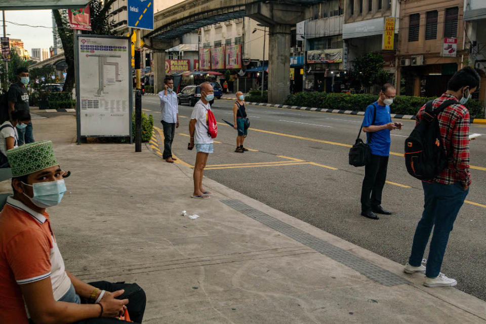 People wearing face masks as a precaution against the spread of Covid-19 wait for a bus in Kuala Lumpur May 31, 2021. — Picture by Firdaus Latif