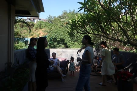 People on a property tour talk outside of a show flat at a residential property developed by Sunac China Holdings in Xishuangbanna, Yunnan