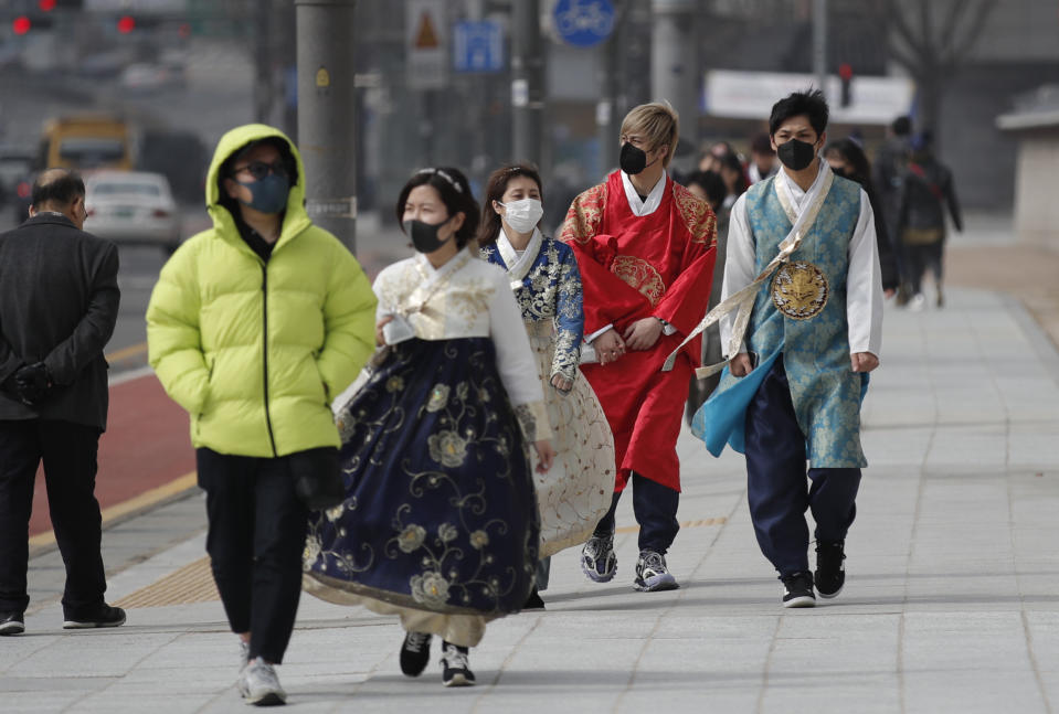 REMOVES REFERENCE TO NUMBER OF VIRAL INFECTIONS - Visitors wearing face masks walk near the Gwanghwamun, the main gate of the 14th-century Gyeongbok Palace, and one of South Korea's well-known landmarks, in Seoul, South Korea, Saturday, Feb. 22, 2020. South Korea's Vice Health Minister Kim Gang-lip says the outbreak has entered a serious new phase but expressed cautious optimism that it can be contained to the region surrounding Daegu, where the first case was reported on Tuesday. (AP Photo/Lee Jin-man)