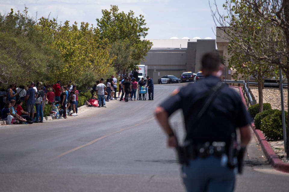 Evacuated people sit outside the Walmart in El Paso, Texas, on Saturday after the mass shooting that claimed at least 20 lives. (Photo: JOEL ANGEL JUAREZ via Getty Images)