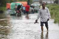 A man wades through a flooded road in Bagha area in Sylhet, Bangladesh, Monday, May 23, 2022. Pre-monsoon deluges have flooded parts of India and Bangladesh, killing at least 24 people in recent weeks and sending 90,000 people into shelters, authorities said Monday. (AP Photo)