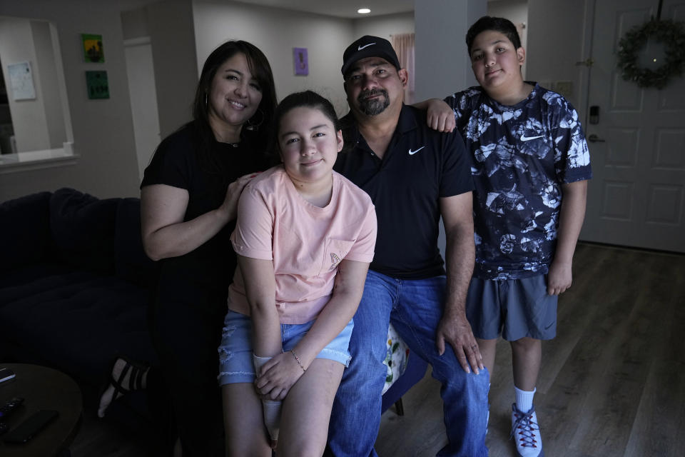 Mayah Zamora, second from left, a survivor of the mass shooting at Robb Elementary in Uvalde, Texas, poses for a photo with her mom Christina, left, dad Ruben, and brother Zach, right, at their home in San Antonio, Tuesday, June 27, 2023. Besides medical bills and the weight of trauma and grief, mass shooting survivors and their family members contend with scores of other changes that show how thoroughly their lives have been upended by violence. (AP Photo/Eric Gay)