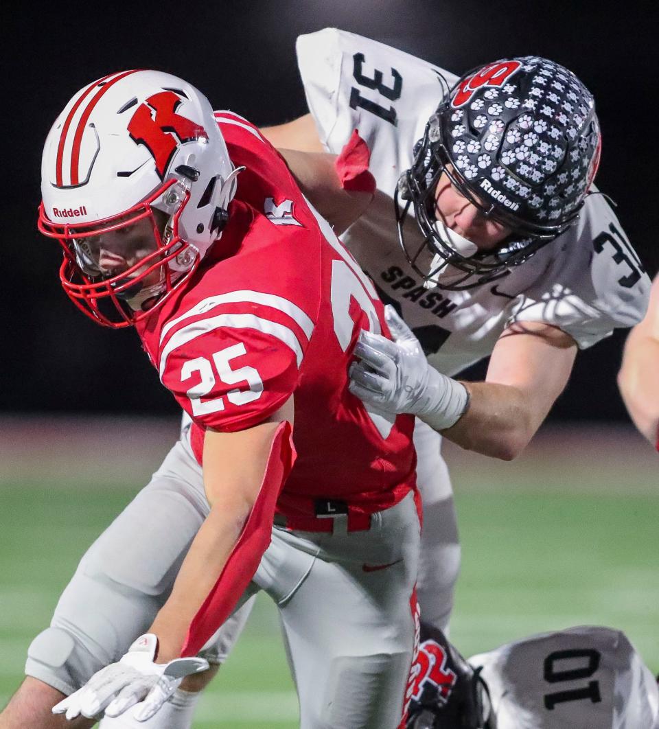 Kimberly's Marcus Doucette (25) tries to break free of Stevens Point's Braylen Nystrom during Friday's WIAA Division 1 second-round playoff game in Kimberly.