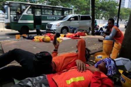 Workers of the Jakarta Mass Rapid Transit construction take a rest during their lunch time at Sudirman Business District in Jakarta, Indonesia, April 17, 2018. Picture taken April 17, 2018. REUTERS/Beawiharta