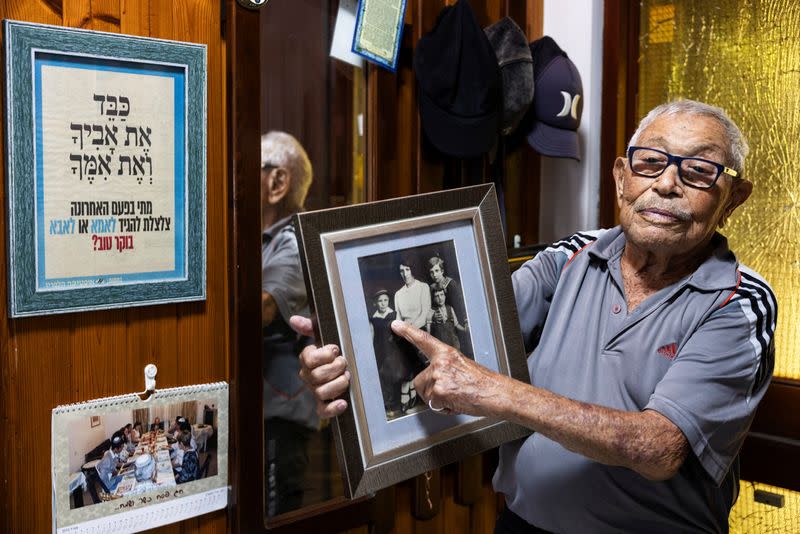 Holocaust survivor Yeshayahu Foyer, 91, shows a family photo of himself as a child during II World War in his house that was hit by a rocket fired from Gaza to Ashkelon