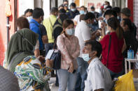 Malaysians wait for their turn to get a coronavirus test outside a clinic in Kajang on the outskirts of Kuala Lumpur, Malaysia, Friday, Oct. 23, 2020. Malaysia restricted movements in its biggest city Kuala Lumpur, neighbouring Selangor state and the administrative capital of Putrajaya from Wednesday in an attempt to curb a sharp rise in coronavirus cases. (AP Photo/Vincent Thian)