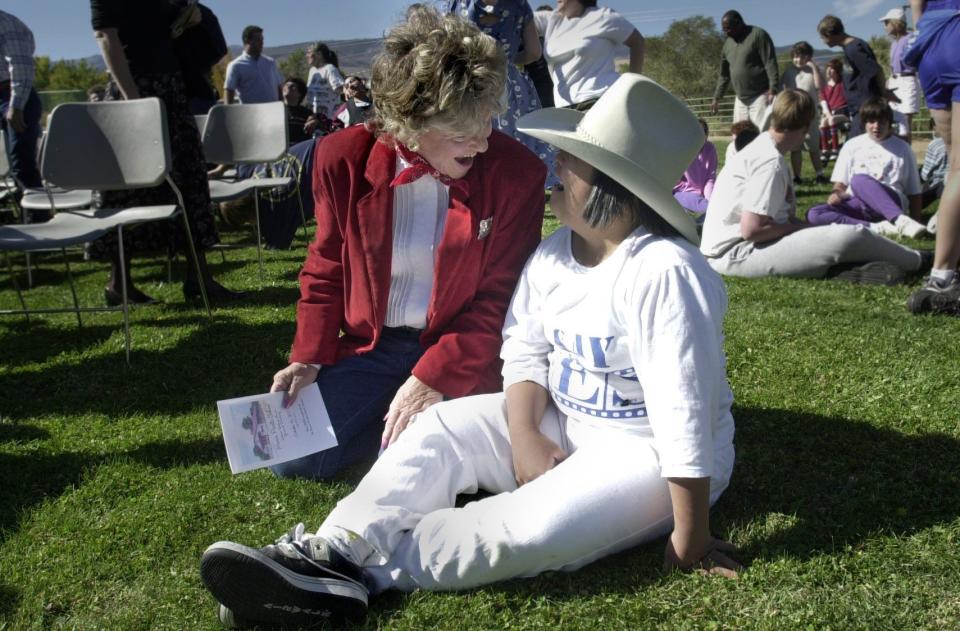 Sherri David, director of the Reno Rodeo, shares her hat with Marvin Picollo student Jennifer Marinez at the ground breaking for a new indoor facility at the school in 2002.