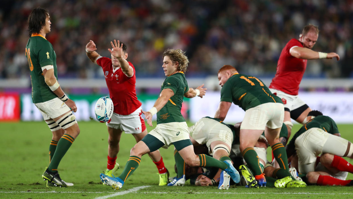 YOKOHAMA, JAPAN - OCTOBER 27: Faf de Klerk of South Africa kicks away from the scrum as Tomos Williams of Wales challenges  during the Rugby World Cup 2019 Semi-Final match between Wales and South Africa at International Stadium Yokohama on October 27, 2019 in Yokohama, Kanagawa, Japan. (Photo by Michael Steele/2019 Getty Images)