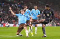 England's Jude Bellingham, right, attempts a shot at goal in front of Belgium's Wout Faes, left, and misses during an international friendly soccer match between England and Belgium at Wembley Stadium, in London, Tuesday, March 26, 2024. (AP Photo/Kirsty Wigglesworth)