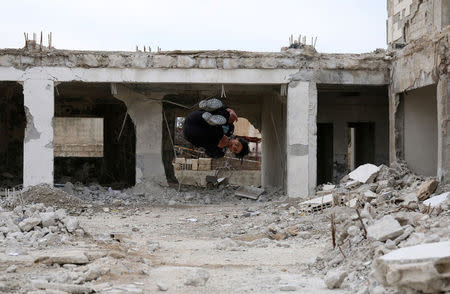 Parkour coach Ibrahim al-Kadiri, 19, demonstrates his Parkour skills amid damaged buildings in the rebel-held city of Inkhil, west of Deraa, Syria, February 4, 2017. Ibrahim and his team members say the sport is a challenge against the bad conditions they have to endure because of the war. REUTERS/Alaa Al-Faqir