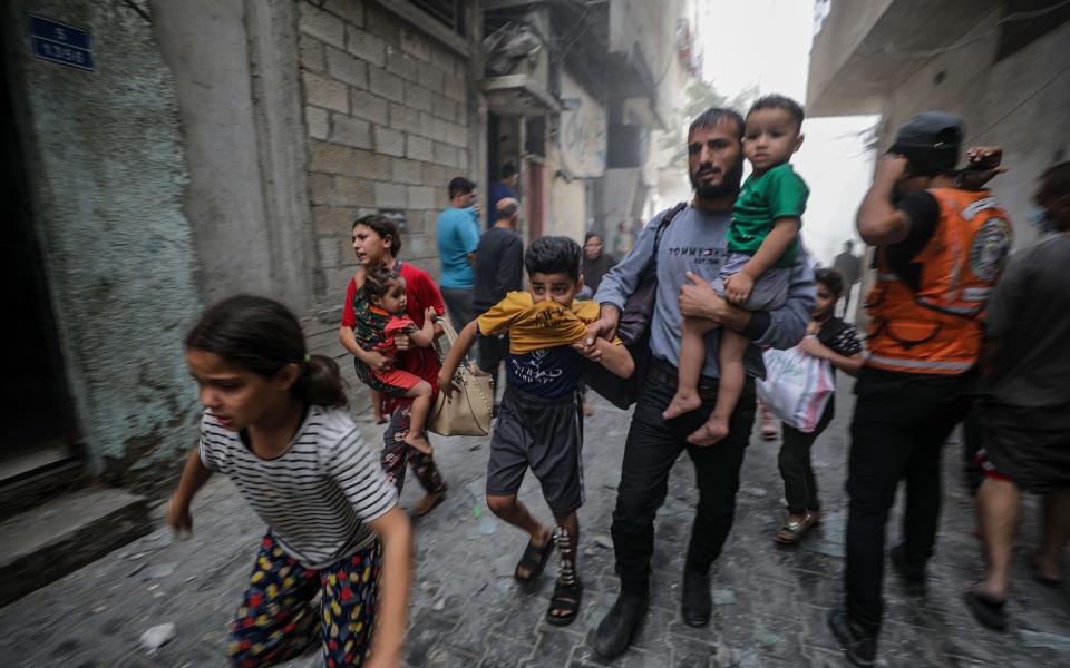 Palestinians flee following an Israeli air strike in Gaza