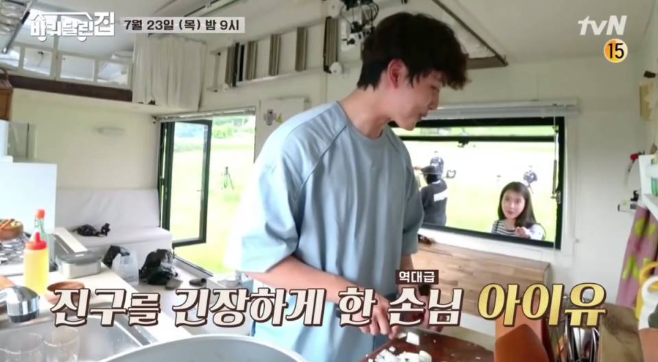 IU作客《小屋漫遊韓半島》，好奇地看呂珍九下廚，讓他害羞地耳朵通紅。（網路圖片）