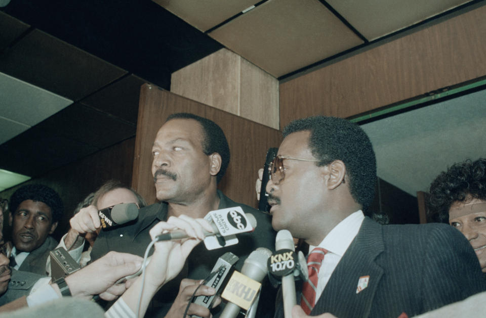 (Original Caption) Former football star Jim Brown (left) and his attorney Johnnie Cochran enter court in L.A. for Brown’s arraignment on three counts of rape and sexual battery. Brown pleaded innocent to all three counts.