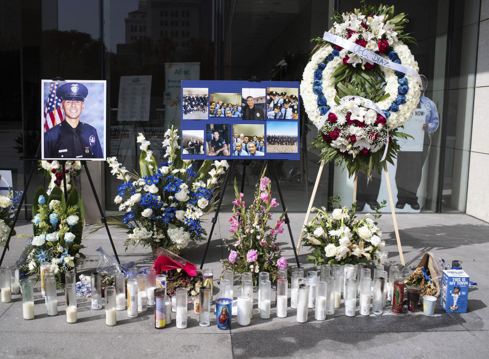 In this Wednesday, July 31, 2019 photo, a memorial for Los Angeles Police Officer Juan Diaz is on display at the Los Angeles Police Department headquarters in Los Angeles. The union that represents Los Angeles Police Department officers says on Friday, Aug. 2, prosecutors should seek the death penalty in the killing of off-duty police Officer Diaz, who was gunned down at a taco stand. Los Angeles Mayor Eric Garcetti says three people have been arrested in Riverside County. (Sarah Reingewirtz/The Orange County Register via AP)