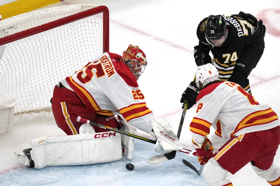 Calgary Flames goaltender Jacob Markstrom (25) makes a save on a shot by Boston Bruins left wing Jake DeBrusk (74) during the second period of an NHL hockey game, Tuesday, Feb. 6, 2024, in Boston. (AP Photo/Charles Krupa)