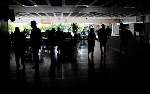 People walk around a shopping People go about their business at a shopping mall in Caracas as the blackout continuesmall in Caracas during the blackout - Credit: Reuters