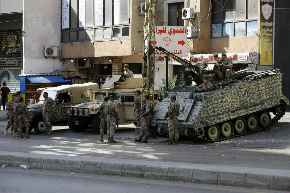 Lebanese army soldiers stand guard at the site where deadly clashes that erupted Thursday along a former 1975-90 civil war front-line between Muslim Shiite and Christian areas, in Ain el-Remaneh neighborhood, Beirut, Lebanon, Friday, Oct. 15, 2021. Schools, banks and government offices across Lebanon shut down Friday after hours of gun battles between heavily armed militias killed six people and terrorized the residents of Beirut. (AP Photo/Bilal Hussein)