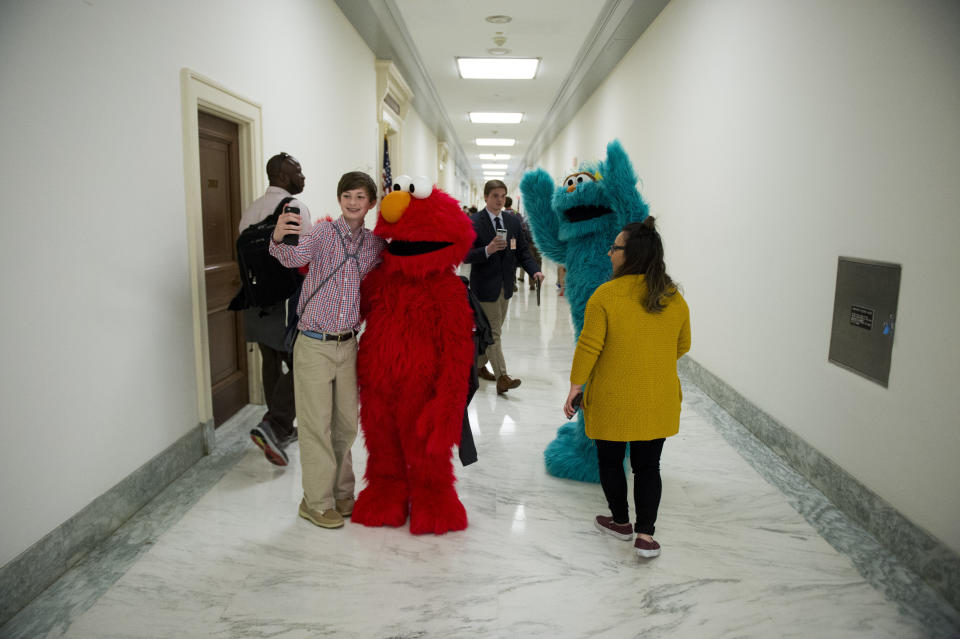 Sesame Street's Elmo and Rosita pose with Capitol visitors as they walk through the halls of the Rayburn House Office Building after participating in the USO event to assemble care packages for troops on May 17, 2016. Some 1,500 care packs were stuffed in celebration of the USO's 75th anniversary.