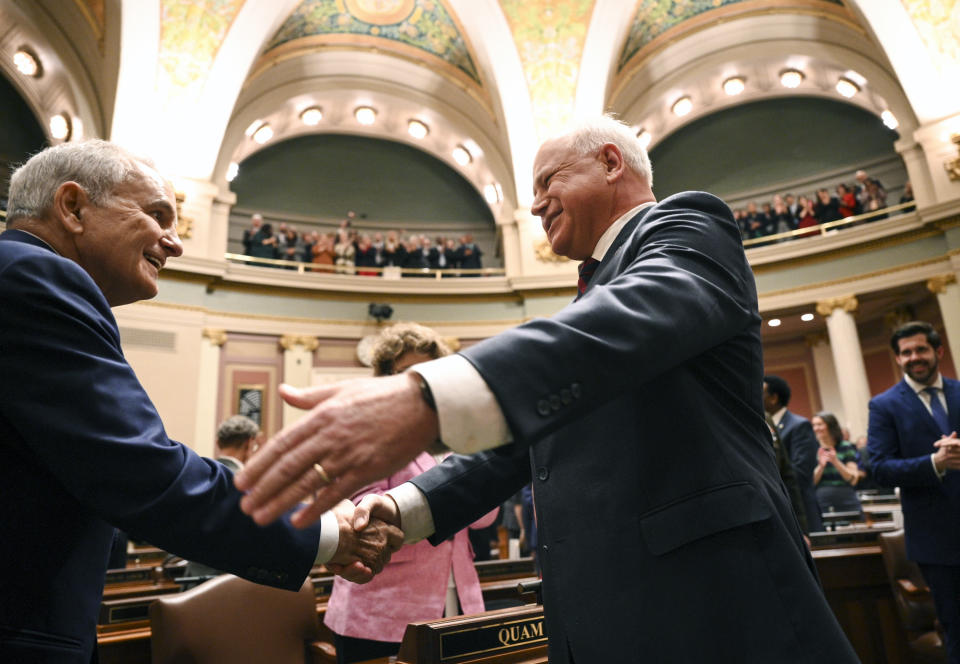 Minnesota Gov. Tim Walz, right, greets distinguished guest and former governor Mark Dayton before Walz delivered the State of the State address, Wednesday, April 19, 2023, in the house chambers of the Minnesota State Capitol in St. Paul, Minn.(Aaron Lavinsky/Star Tribune via AP)