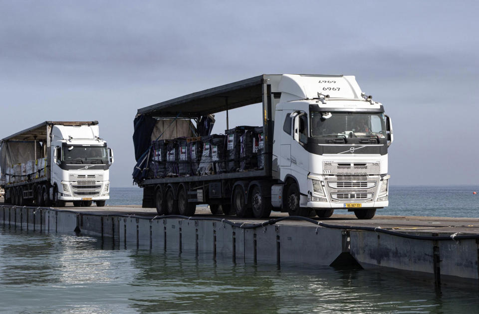 FILE - This image provided by the U.S. Army shows trucks loaded with humanitarian aid from the United Arab Emirates and the United States Agency for International Development cross the Trident Pier before arriving on the beach on the Gaza Strip, May 17, 2024. The U.S.-built pier to bring food to Gaza is facing one of its most serious challenges yet. The United Nations is deciding if it can keep safely delivering supplies from the U.S. sea route to starving Palestinians (Staff Sgt. Malcolm Cohens-Ashley/U.S. Army via AP, File)