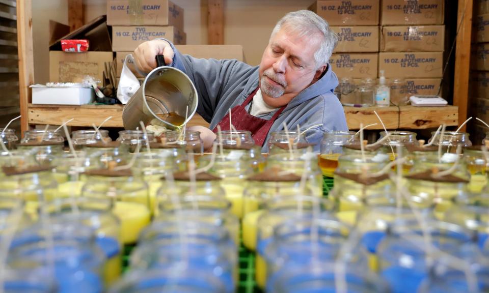 Door County Candle Co. candlemaker Larry Mickelson pours wax to make Ukraine Candles tin the blue and yellow colors that represent that country. The Sturgeon Bay candle making business has raised more than $700,000 for relief organization Razom for Ukraine through sales of the candles and is now launching a #LighttoUnite campaign to push the total to $1 million.